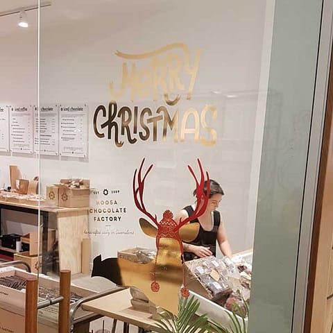 Door and Window Graphics. Gold mirror cut vinyl graphics for Noosa Chocolate Factory. Merry Christmas window signage.