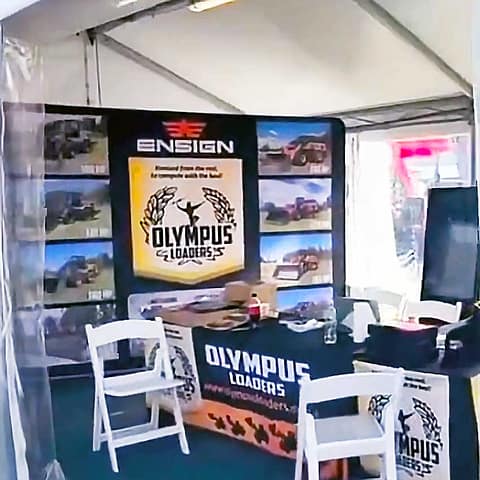 Olympus display at Beef 2024 with table cloths media walls and digital display