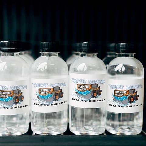 Custom printed water bottle labels for corporate advertising at events.